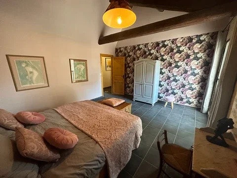 Chambre fleurie avec lit double et poutres apparentes au Domaine Les Barrettes Agde, hébergement mariage Hérault