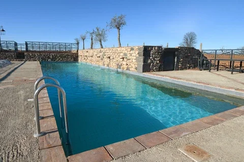 Piscine extérieure du Domaine Les Barrettes à Agde, Hérault - eau turquoise et murets en pierre