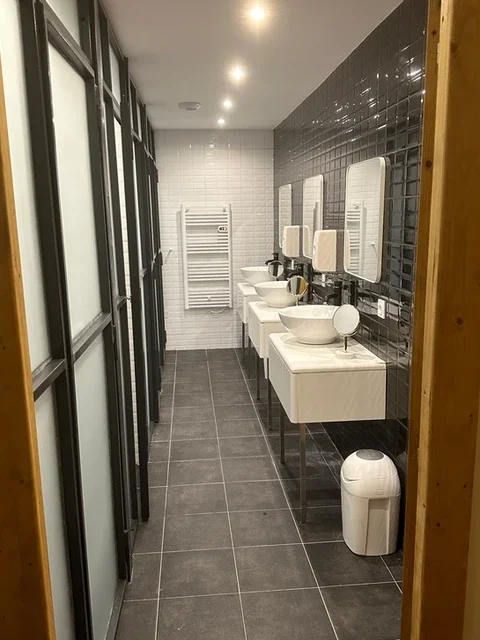 Salle de bains collective moderne avec vasques et carrelage gris au Domaine Les Barrettes Agde Hérault