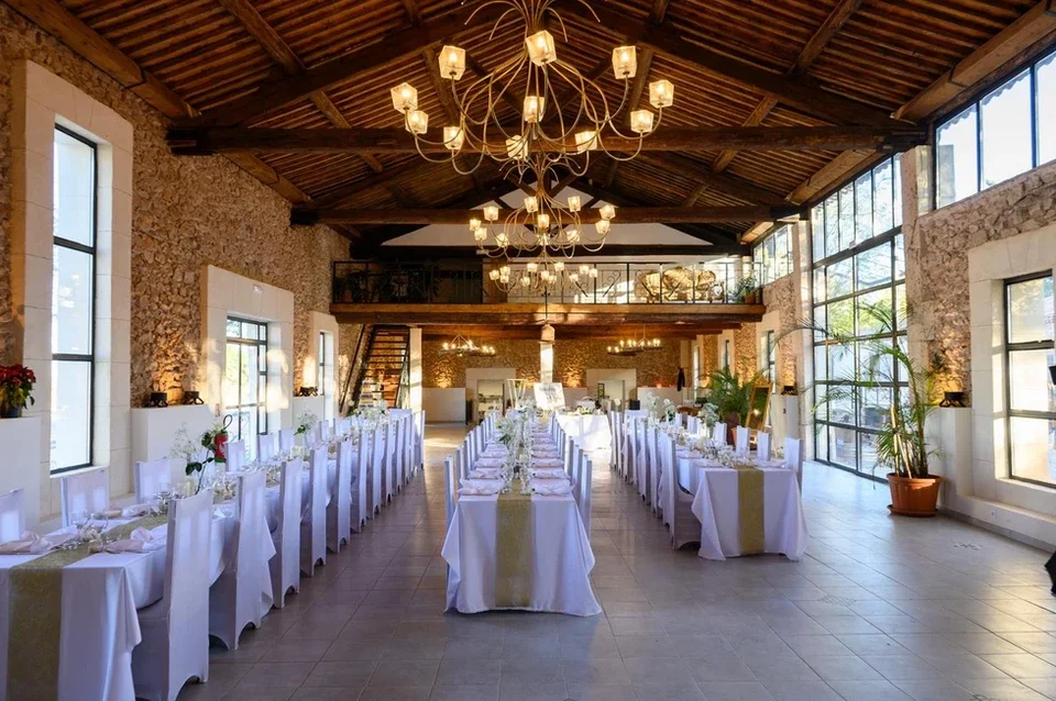 Salle de réception mariage Domaine Les Barrettes Agde - lustre, charpente bois et murs en pierre Hérault