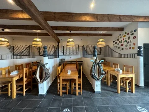 Salle de réception avec poutres apparentes et tables en bois au Domaine Les Barrettes Agde pour un mariage dans l'Hérault