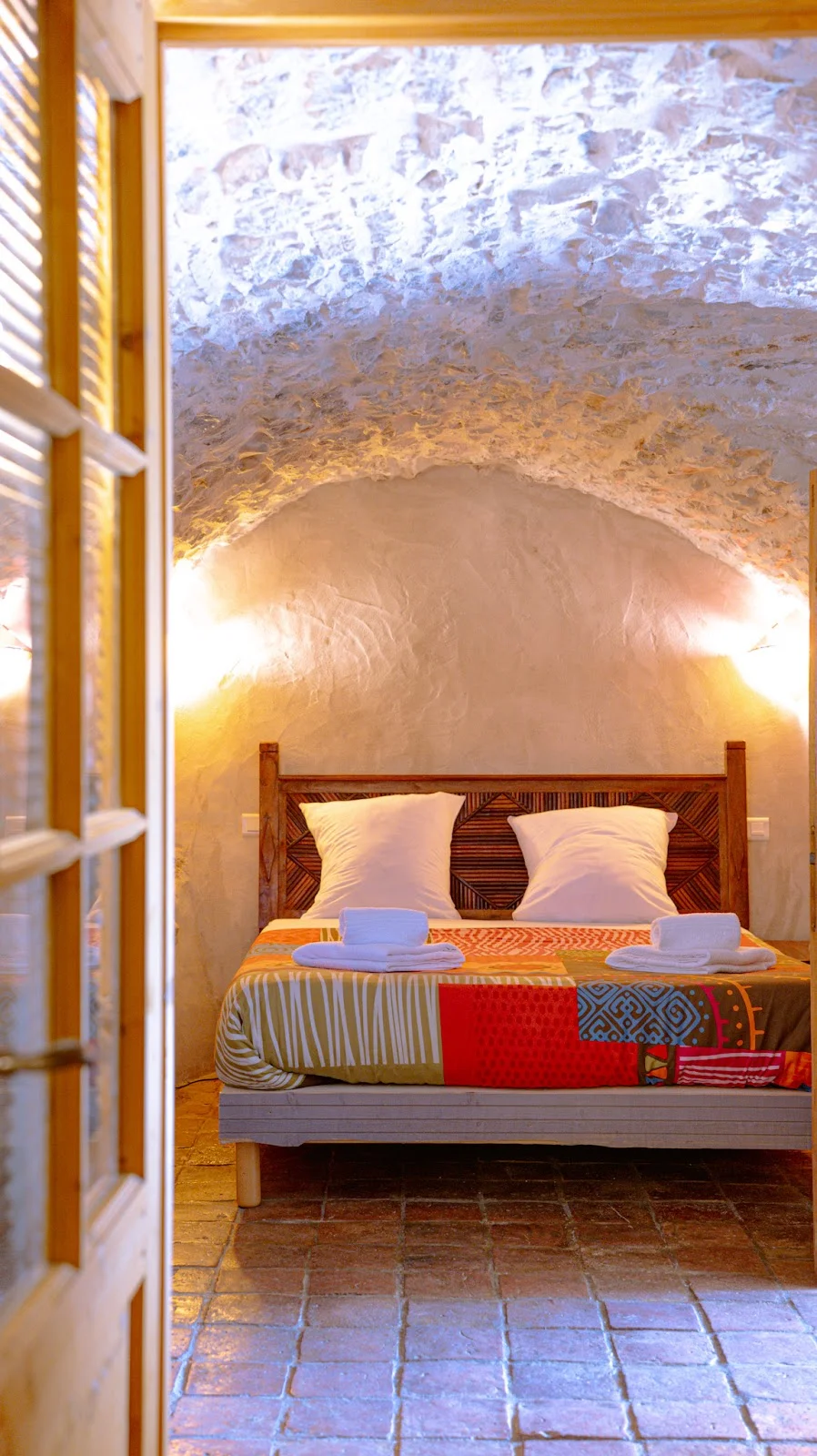 Chambre voûtée en pierre du Domaine du Mas de Coulet avec lit double et tomettes, hébergement mariage Hérault