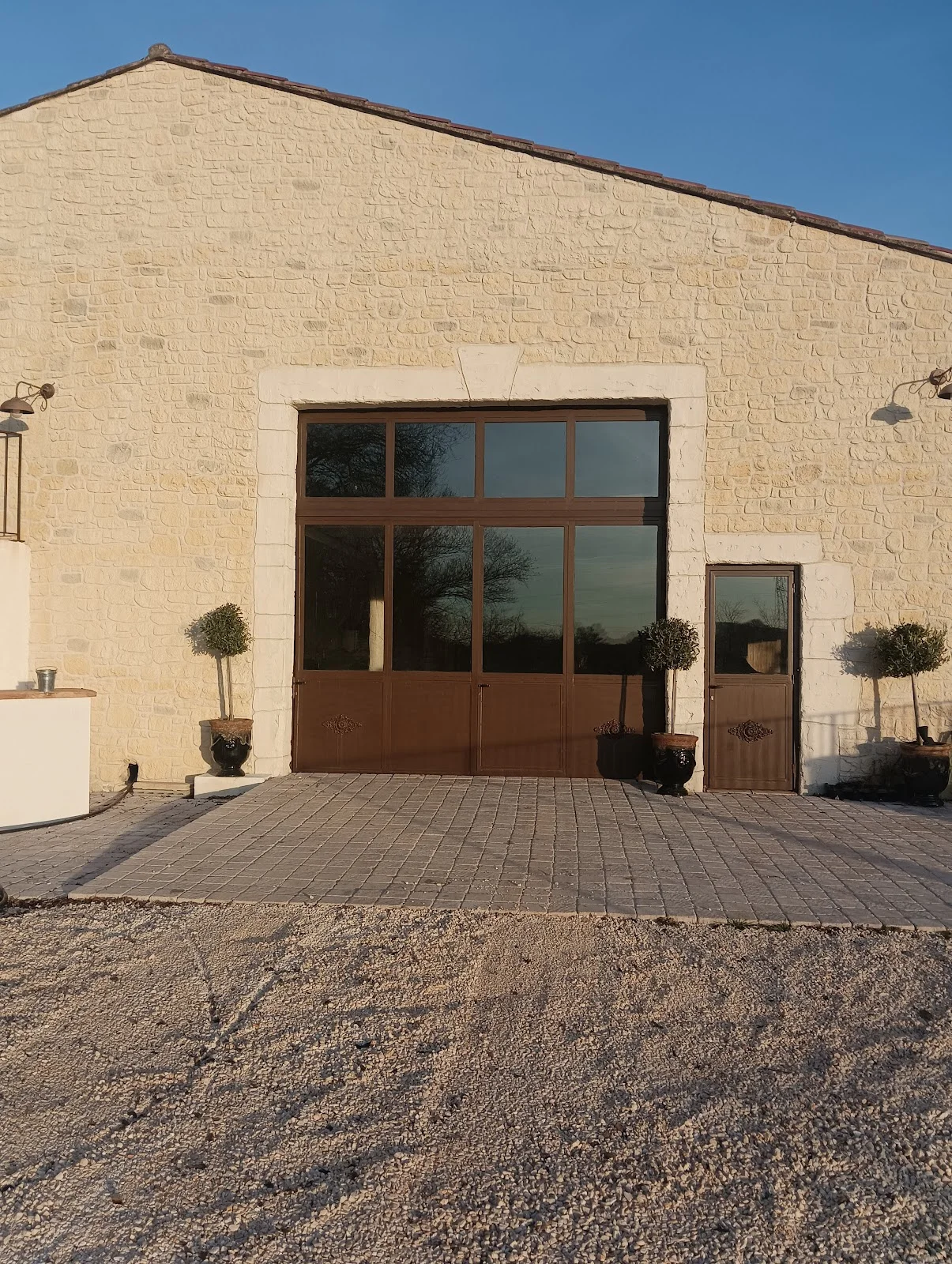 Façade en pierre de la salle de réception du Domaine du Mas de Mare dans l'Hérault, grange rénovée avec verrière pour mariage