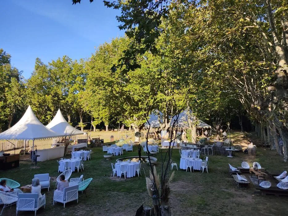 Jardin arboré, tentes blanches, tables rondes, mobilier lounge, ambiance festive Domaine Pech Laurier Quarante mariage Hérault Occitanie
