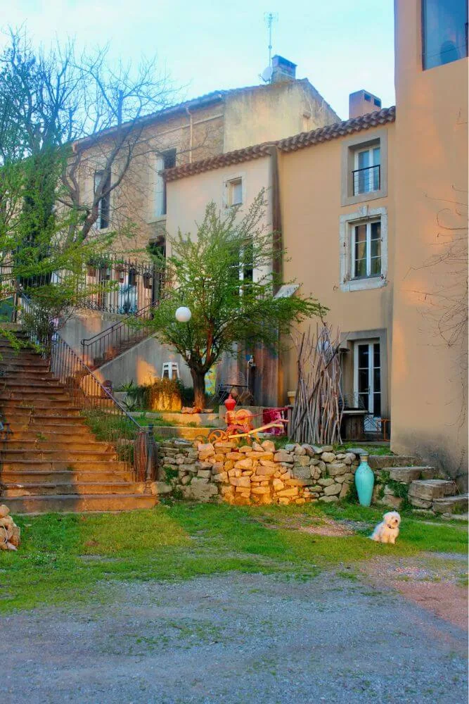 Façade pierres apparentes, escalier extérieur, jardin verdoyant, ambiance chaleureuse, Domaine Pech Laurier Quarante mariage Hérault Occitanie