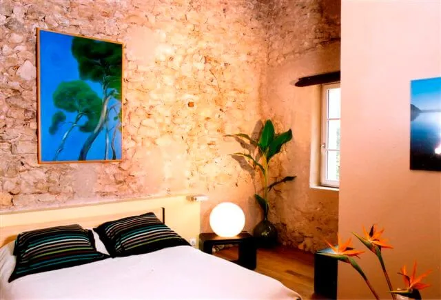 Chambre rustique murs pierre, lit confortable, décoration moderne, ambiance chaleureuse Domaine Pech Laurier Quarante mariage Hérault Occitanie