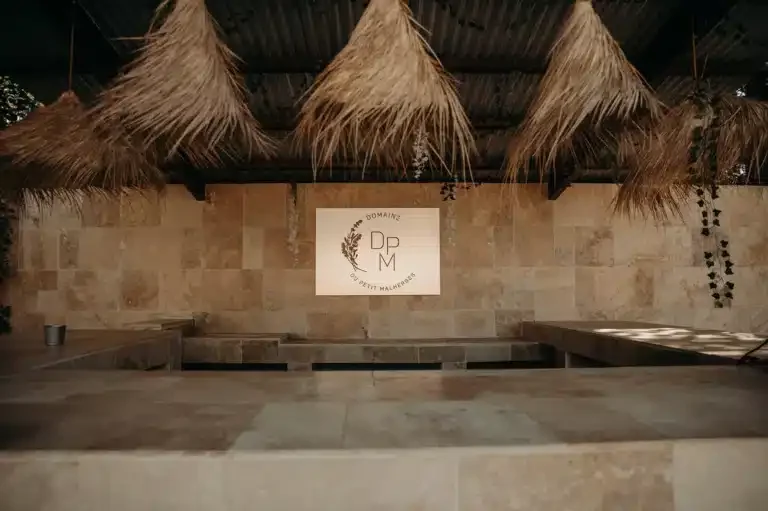 Logo DpM illuminé dans la salle de réception du Domaine Le Petit Malherbes, mariage Hérault