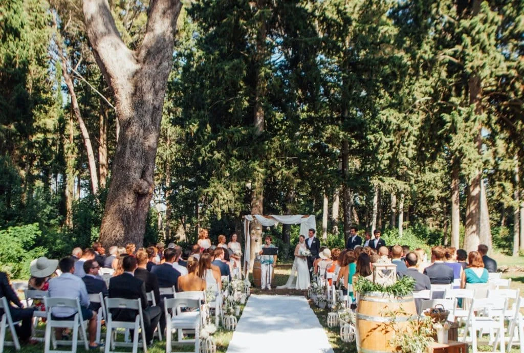 Vue d'ensemble de la cérémonie de mariage en plein air dans le parc boisé du Domaine Saint Hilaire en Hérault