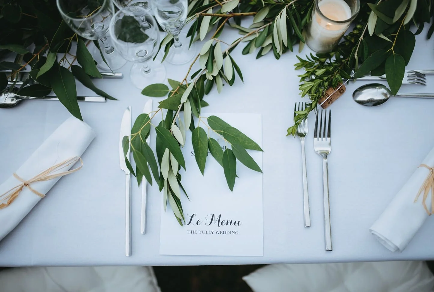 Détail couvert mariage avec menu calligraphié et branche d'eucalyptus au Domaine Saint-Hilaire dans l'Hérault
