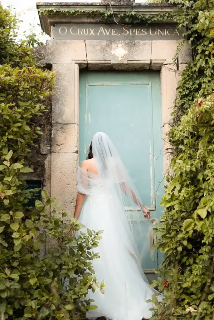 Mariée chapelle ancienne porte bleue végétalisée Domaine Saint Jean de Roca mariage Hérault