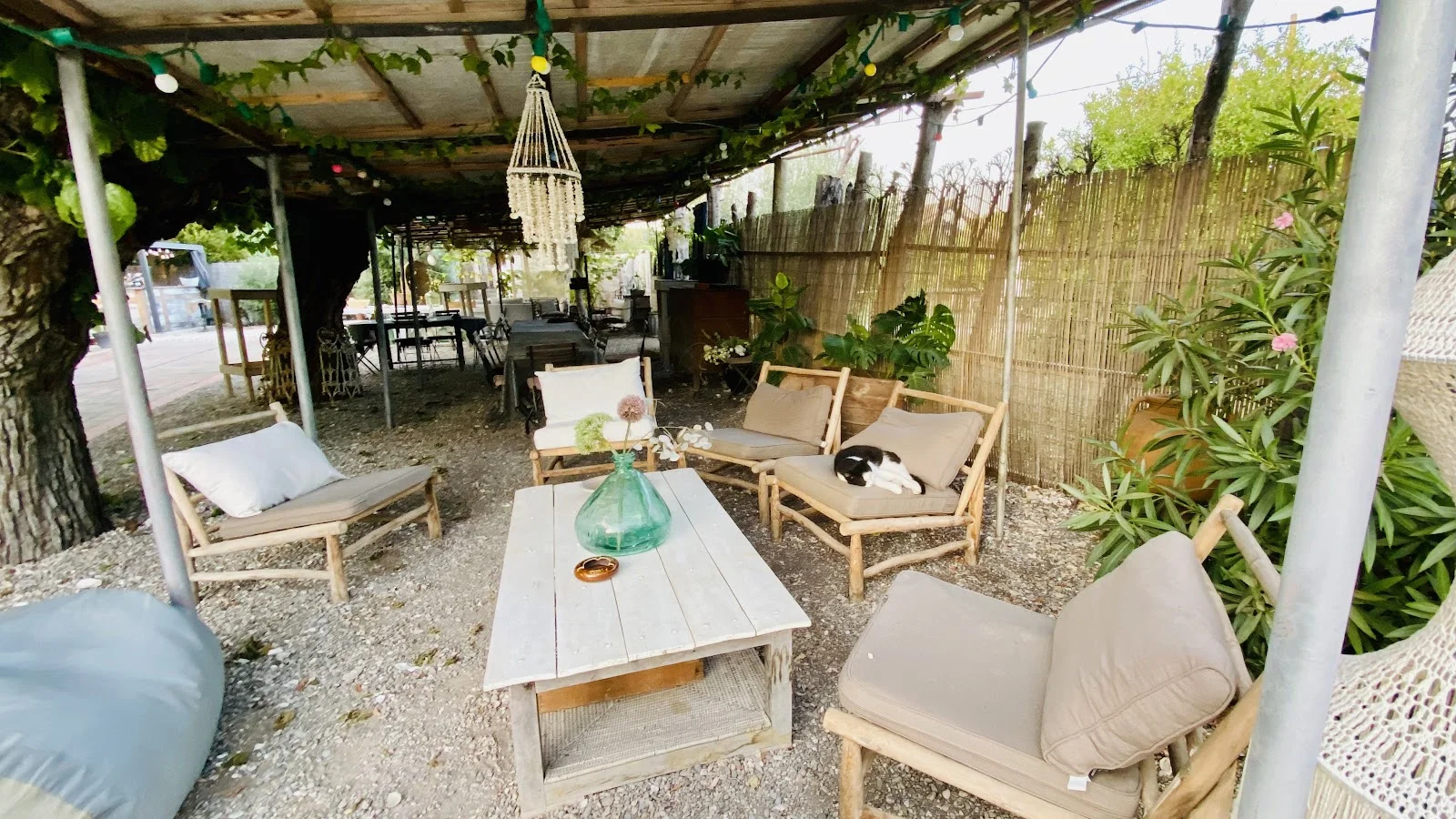 Espace lounge sous pergola avec canapés bois et guirlandes lumineuses au Domaine Saint Paul le Marseillais, cocktail mariage Hérault