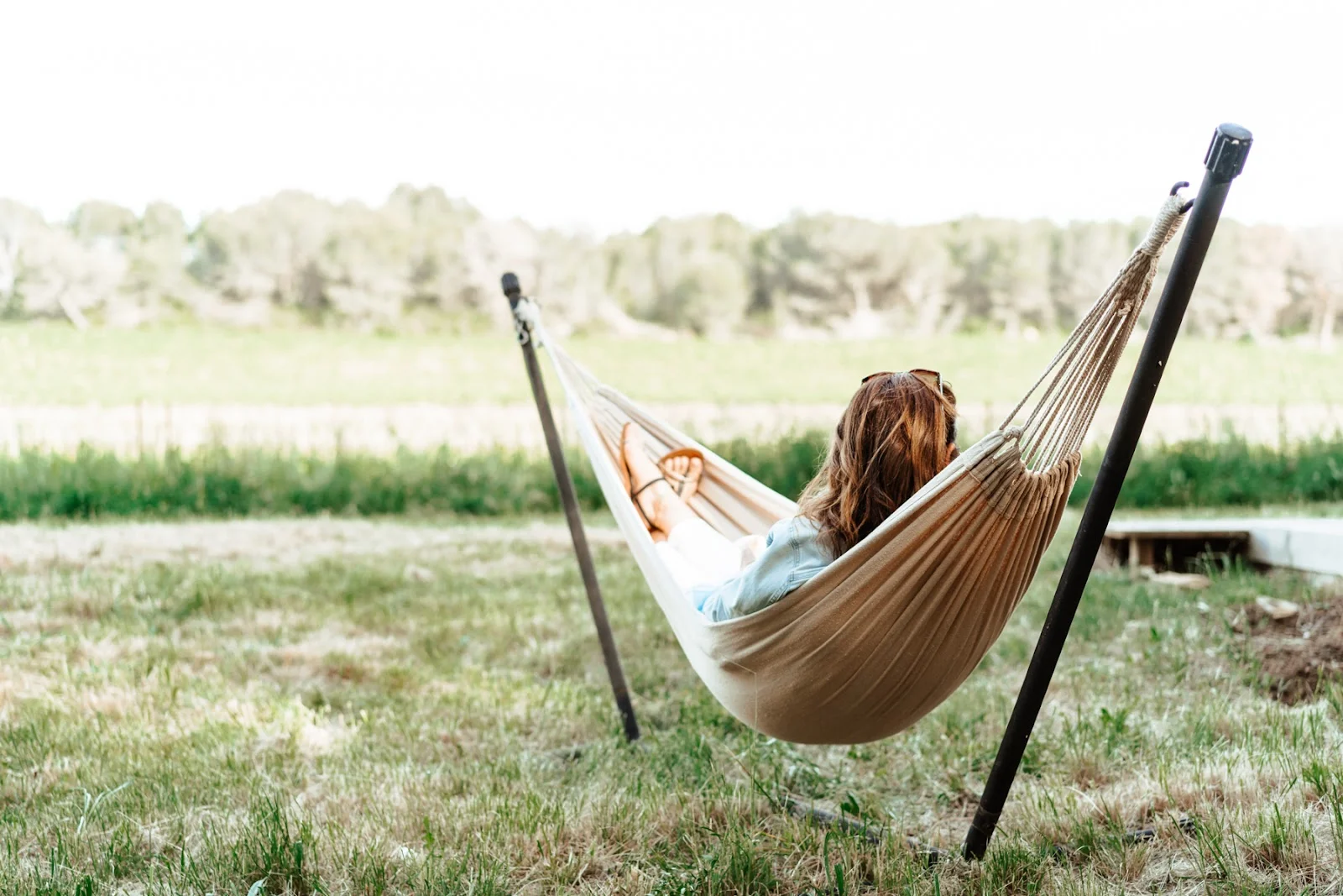 Personne se relaxant dans un hamac face à la prairie verte au Domaine Saint Paul le Marseillais, détente nature mariage Hérault