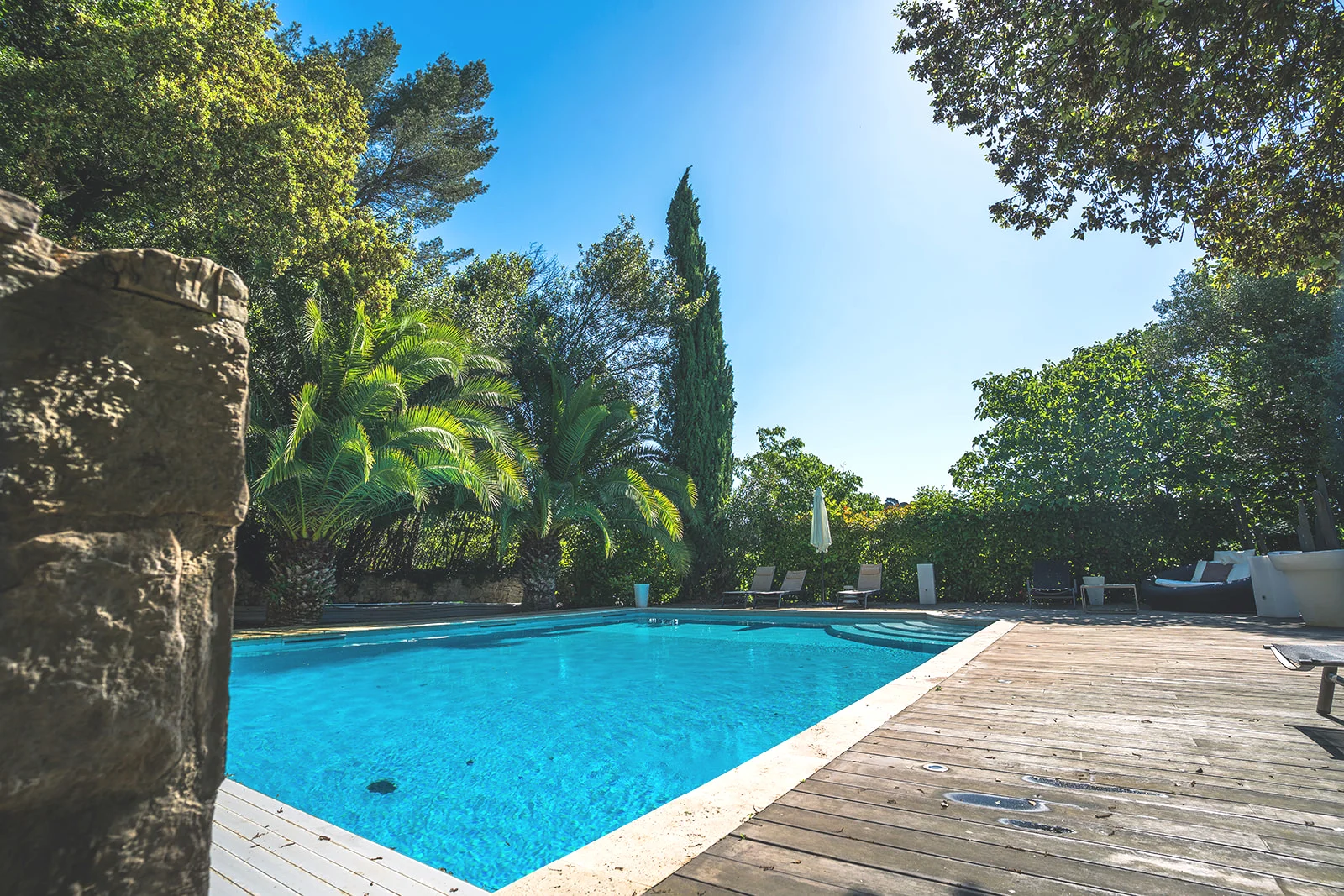 Piscine La Bastide Castella avec terrasse bois et végétation méditerranéenne - domaine mariage Hérault
