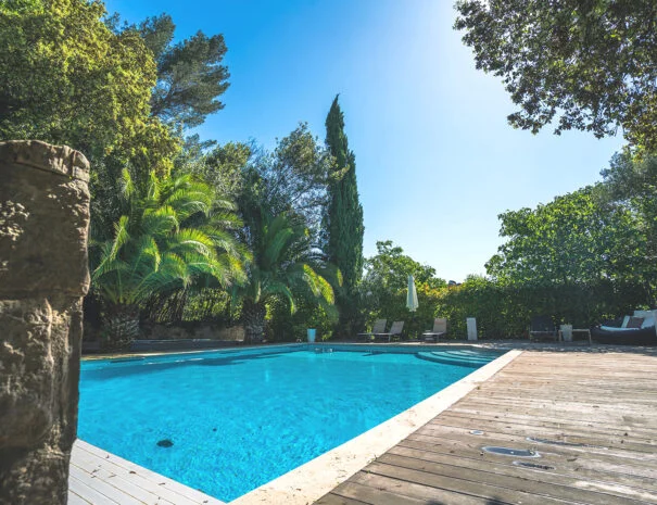 Piscine turquoise avec terrasse en bois de La Bastide Castella, domaine mariage Hérault