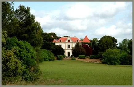 La Bellonette manoir de mariage dans l'Hérault vu depuis la prairie verdoyante avec toits rouges