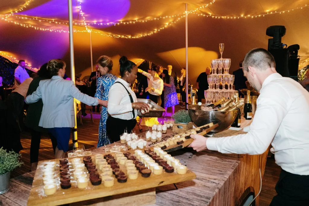Buffet cocktail et pyramide de champagne sous tente lors d'un mariage au Domaine La Trésorière en Hérault