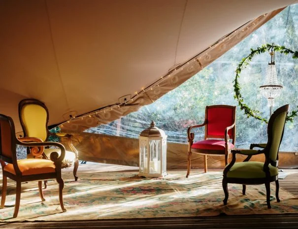 Espace lounge bohème sous tente La Trésorière Hérault avec fauteuils colorés et arche végétale