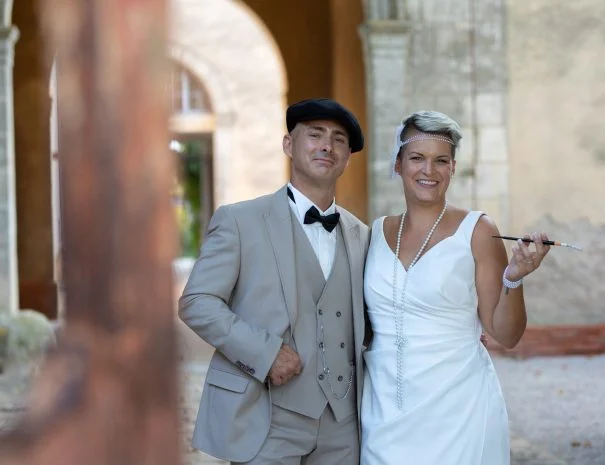 Couple de mariés style années 20 Great Gatsby sous les arcades de La Trésorière, mariage thématique Hérault