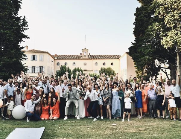Photo de groupe mariage La Trésorière, mariés et invités devant la bâtisse provençale dans le parc, Hérault