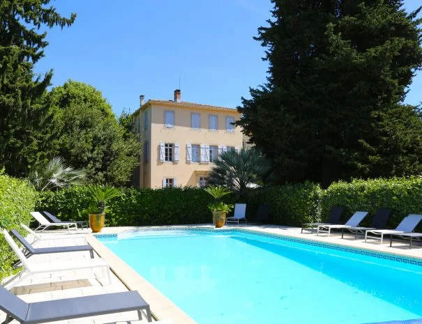 Piscine extérieure de La Trésorière avec vue sur la bâtisse provençale et végétation méditerranéenne, domaine mariage Hérault