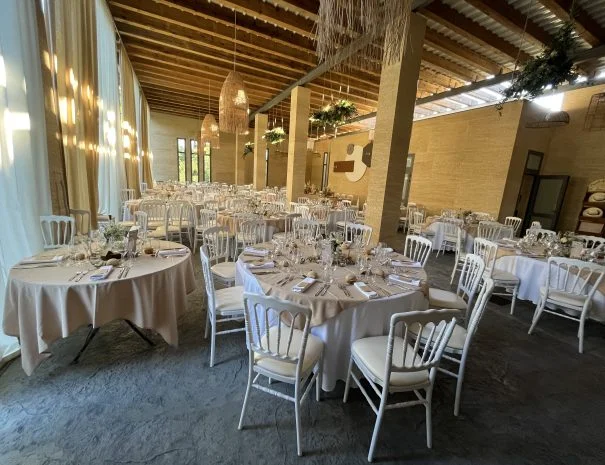 Salle de réception mariage La Trésorière Hérault avec chaises Napoléon blanches et suspensions rotin