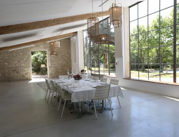 Salle avec verrière industrielle et table dressée pour mariage à La Trésorière dans l'Hérault