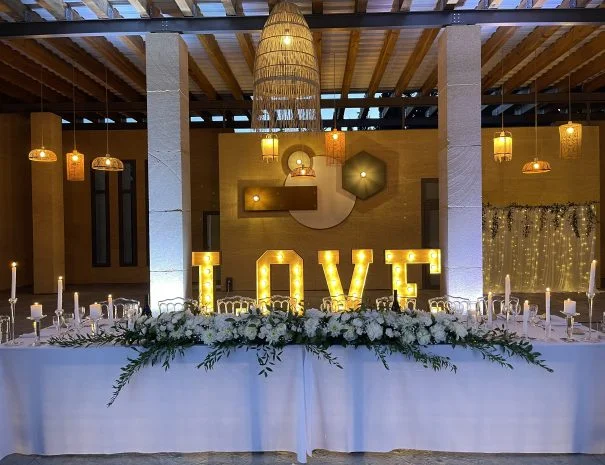 Table d'honneur mariage La Trésorière Hérault avec lettres lumineuses LOVE et composition florale blanche