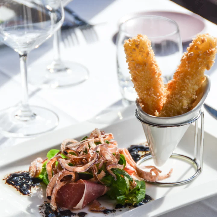 Entrée jambon cru bâtonnets frits et roquette au balsamique restaurant Le Grand Arbre Château de Bionne Hérault