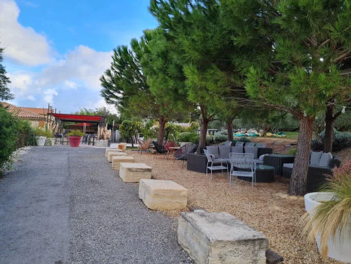 Jardin du Mas de Laux avec allée en graviers, blocs de pierre et salon extérieur, domaine mariage Hérault