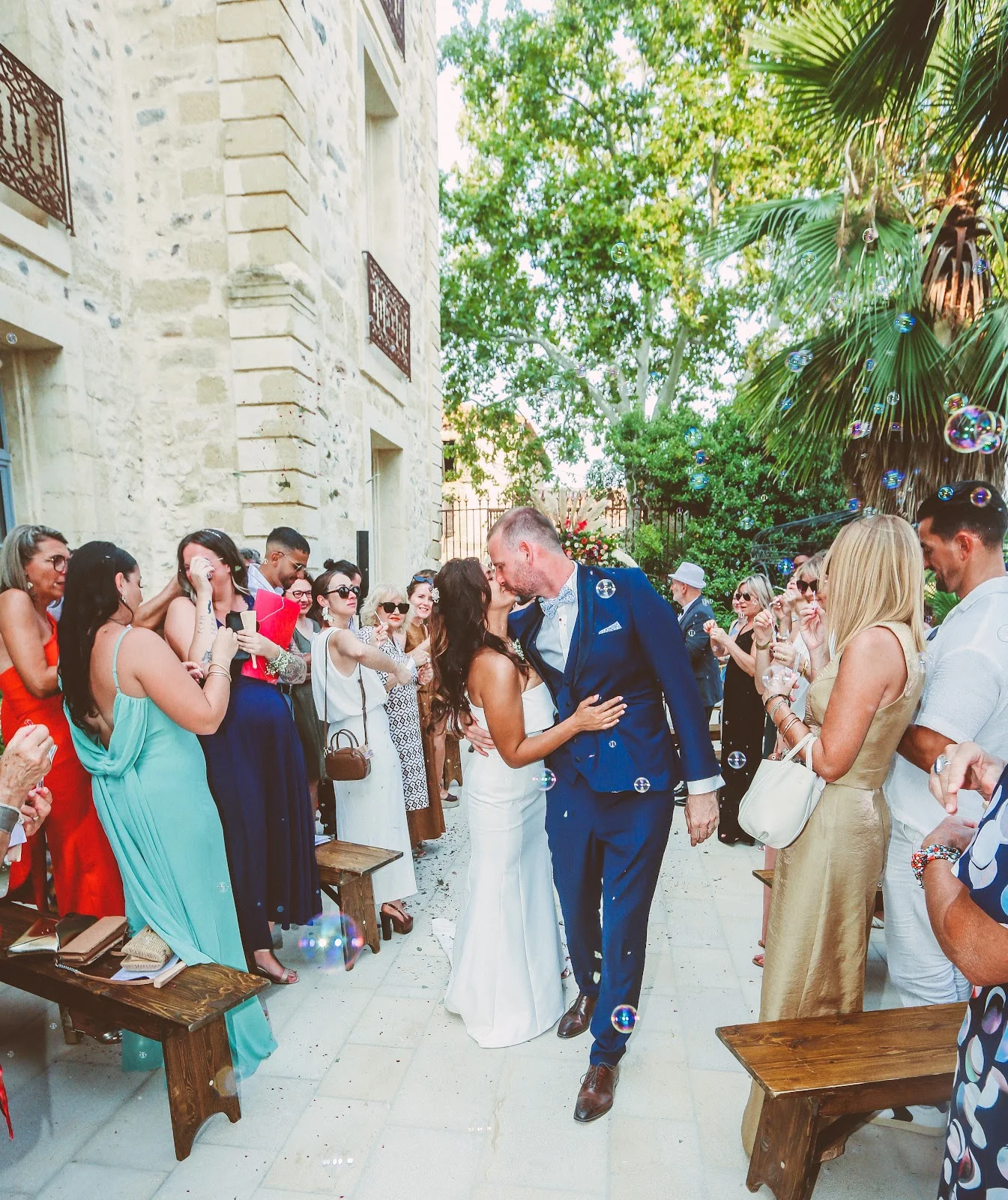 Cérémonie de mariage en plein air au domaine Les Castans en Hérault avec bulles de savon et invités festifs