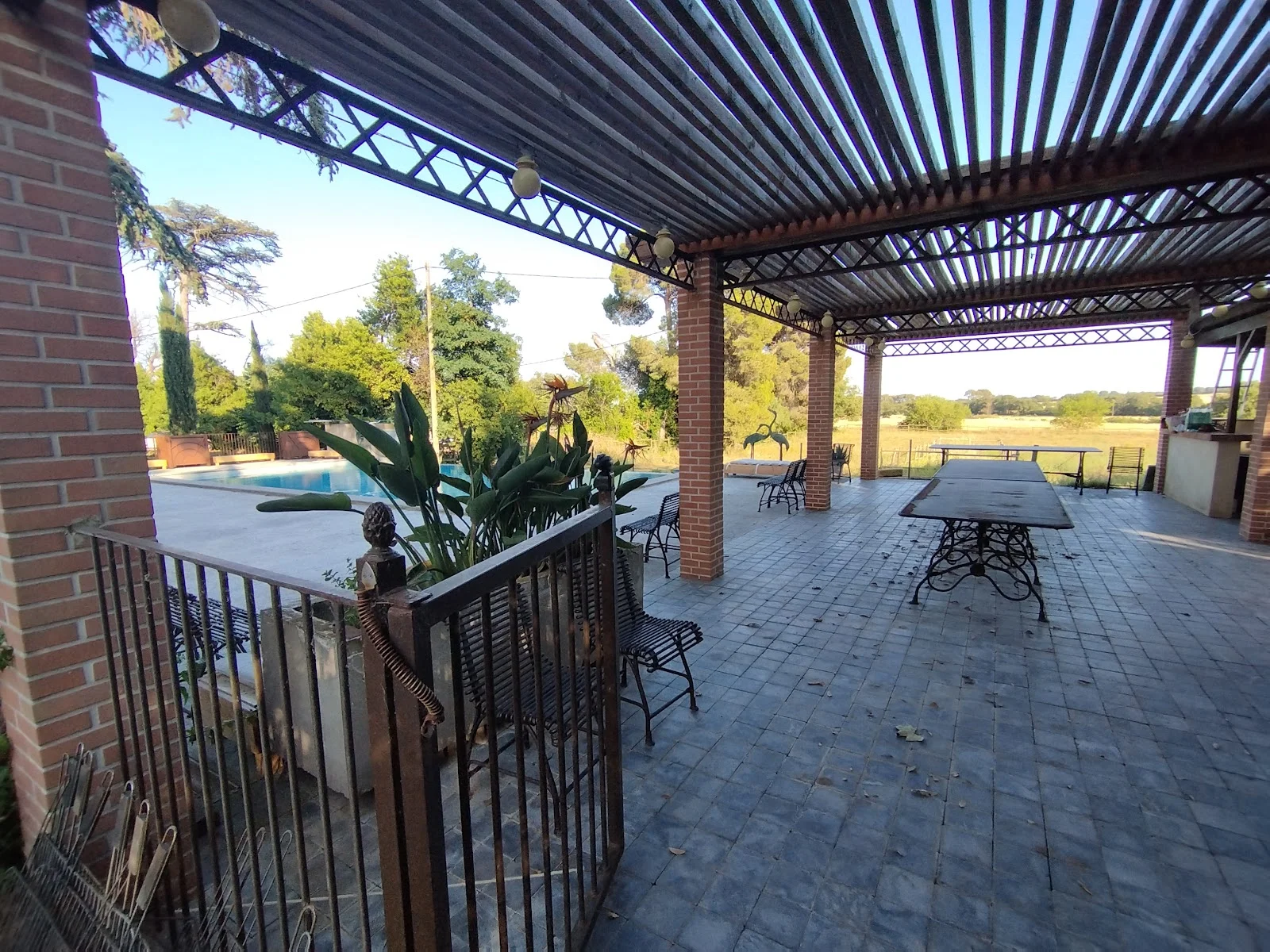 Terrasse avec pergola et vue sur la piscine du domaine Les Castans, espace cocktail mariage en Hérault