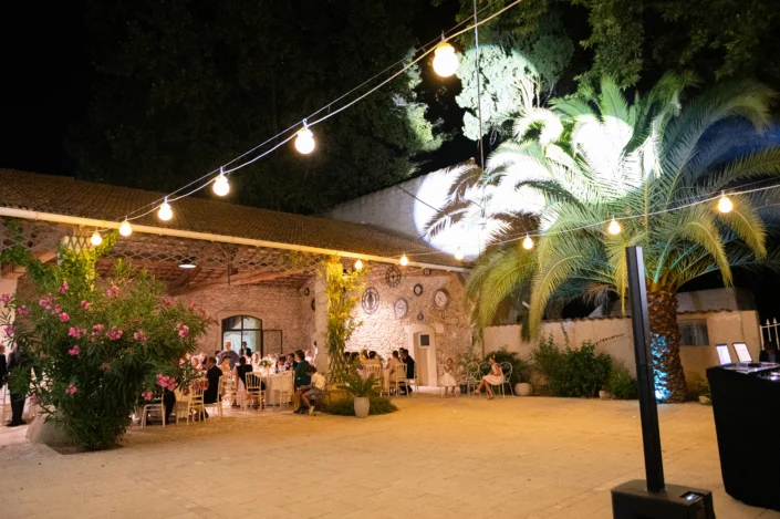 Réception de mariage nocturne avec guirlandes lumineuses au domaine Les Charmes de Bailly en Hérault, ambiance festive en Occitanie