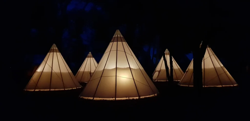 Six tipis illuminés nuit parc Les Charmes de Bailly hébergement mariage Hérault