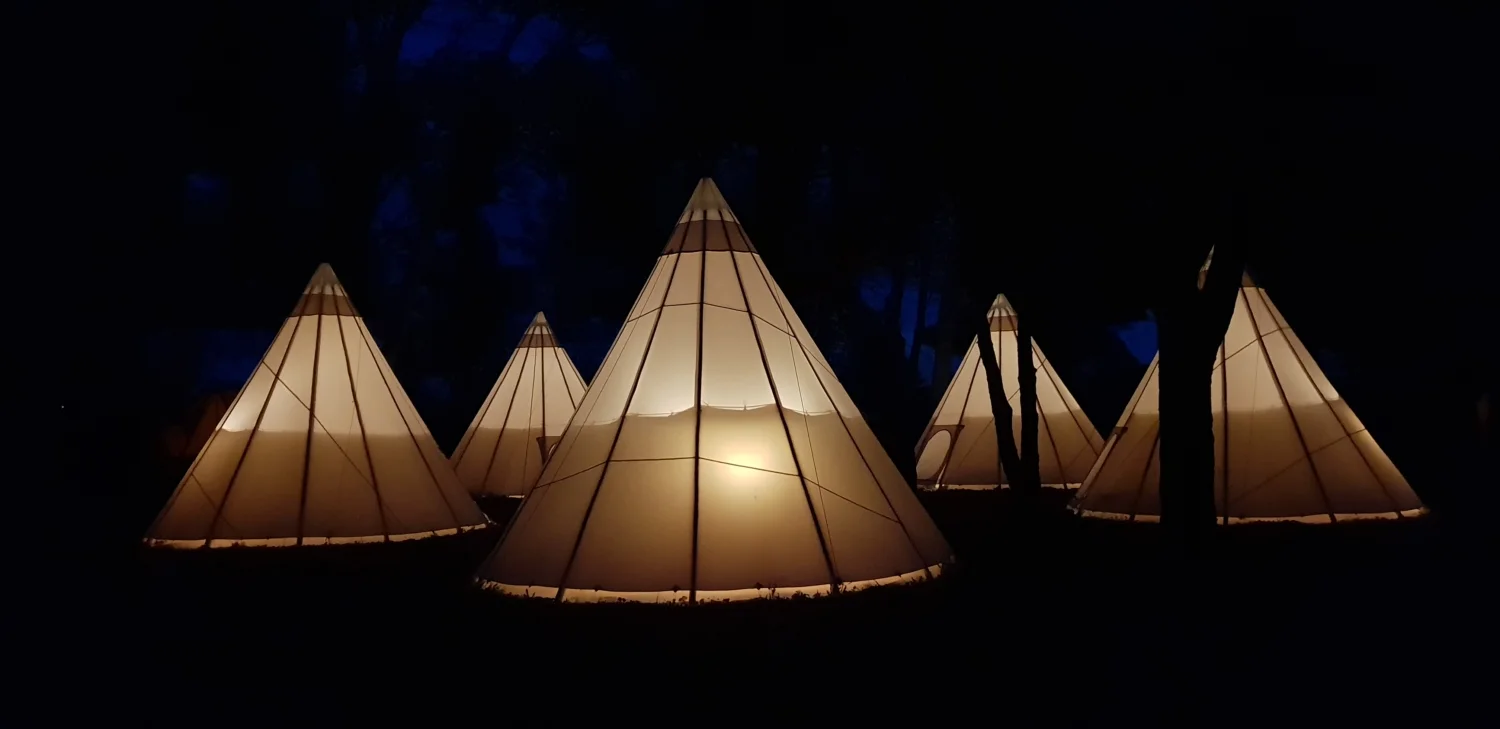 Tipis illuminés la nuit au domaine Les Charmes de Bailly en Hérault pour mariage ou séjour insolite en Occitanie