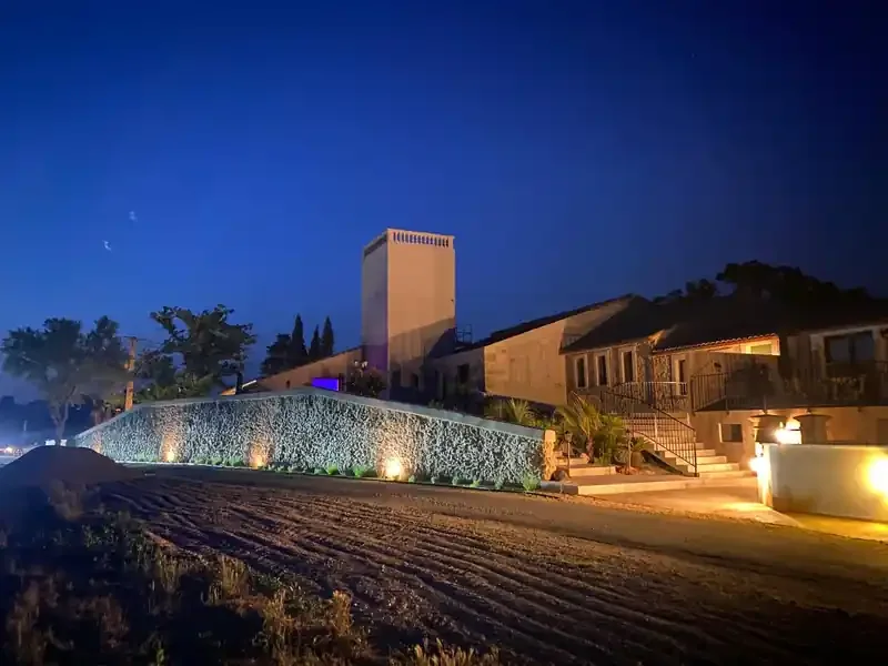 Domaine Les Granges Saint Paul illuminé de nuit avec tour bleue et mur gabion en Hérault