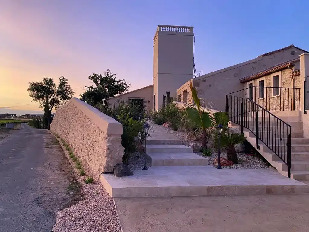 Extérieur Les Granges Saint-Paul au coucher du soleil, escalier en pierre et palmiers, domaine mariage Hérault