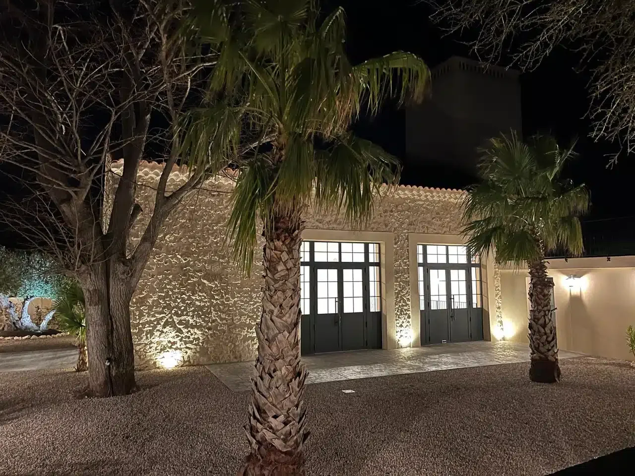 Façade principale Les Granges Saint-Paul illuminée de nuit avec palmiers et tour, salle mariage Hérault