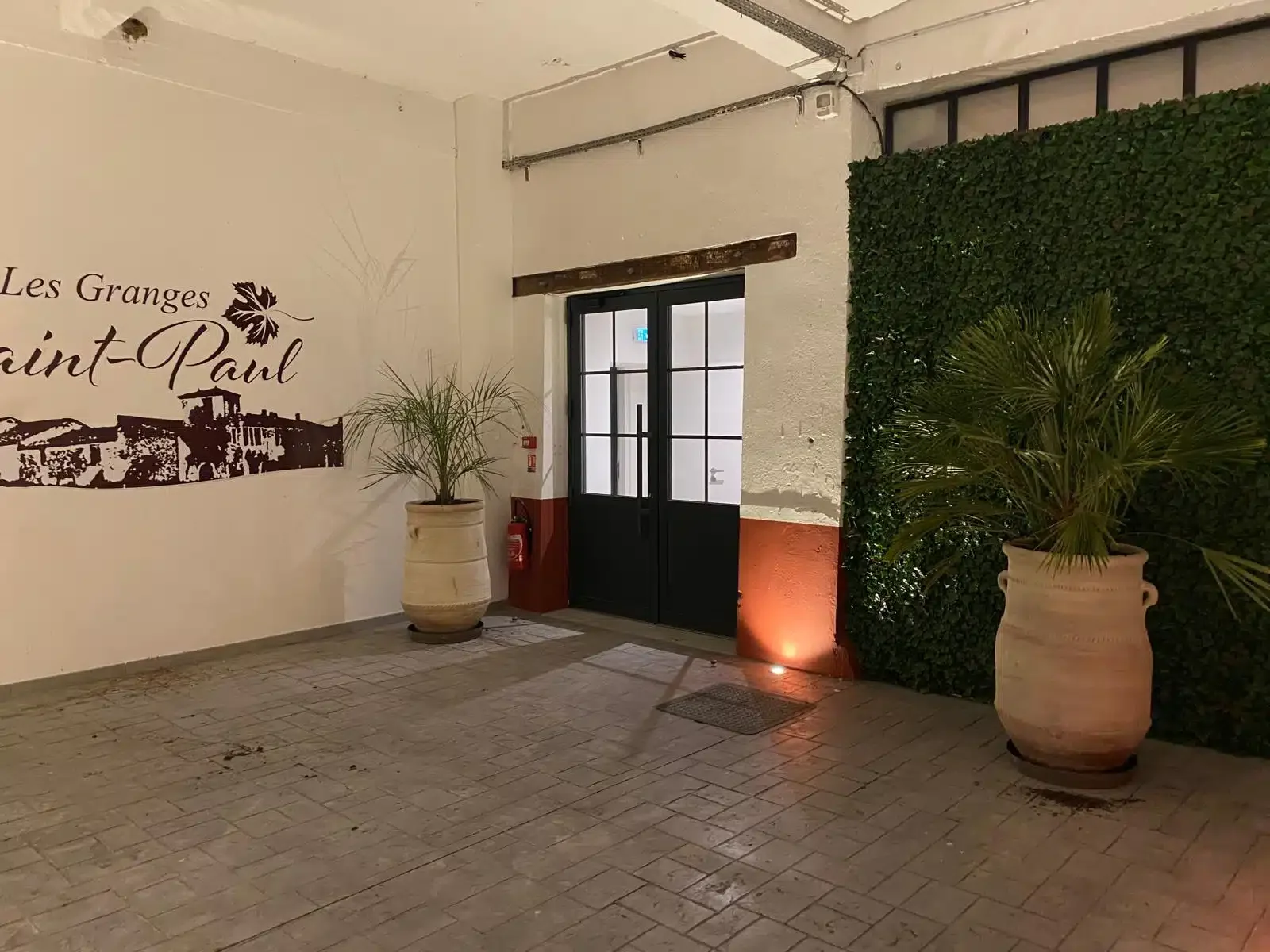 Hall d'entrée Les Granges Saint-Paul avec logo mural et mur végétal, domaine événementiel Hérault