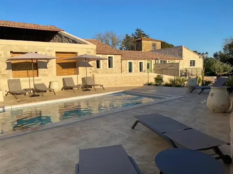 Piscine avec terrasse et vue sur les bâtiments en pierre - Les Granges Saint Paul, domaine mariage Hérault