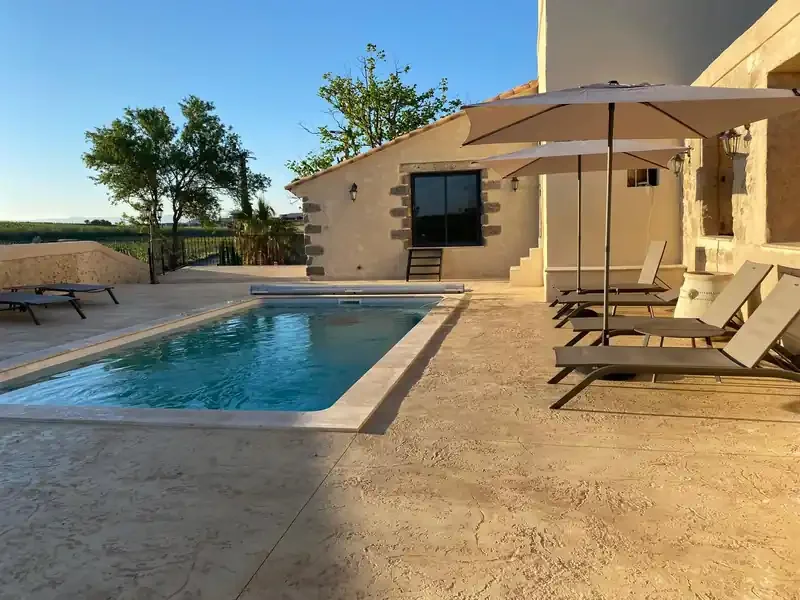 Piscine avec transats et vue sur le bâtiment en pierre - Les Granges Saint Paul, domaine mariage Hérault