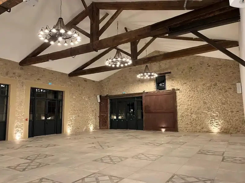 Salle de réception en pierre avec charpente bois et lustres - Les Granges Saint Paul, mariage Hérault