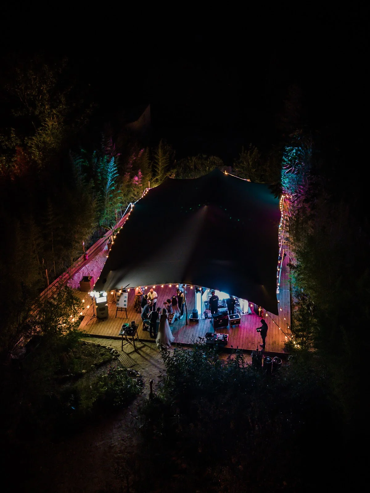 Vue aérienne nocturne de L'Impensable à Aniane, salle de réception en forêt avec guirlandes lumineuses, mariage Hérault