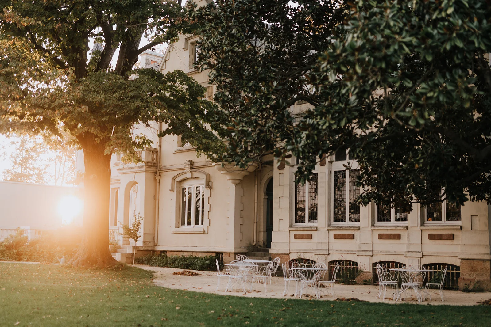 Façade extérieure Maison Jullian Hérault au coucher du soleil avec jardin et mobilier blanc pour mariage