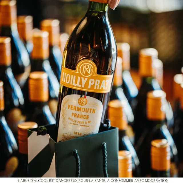 Bouteille Noilly Prat Ambré dans un sac cadeau vert, idée cadeau vermouth Maison Noilly Prat Marseillan Hérault