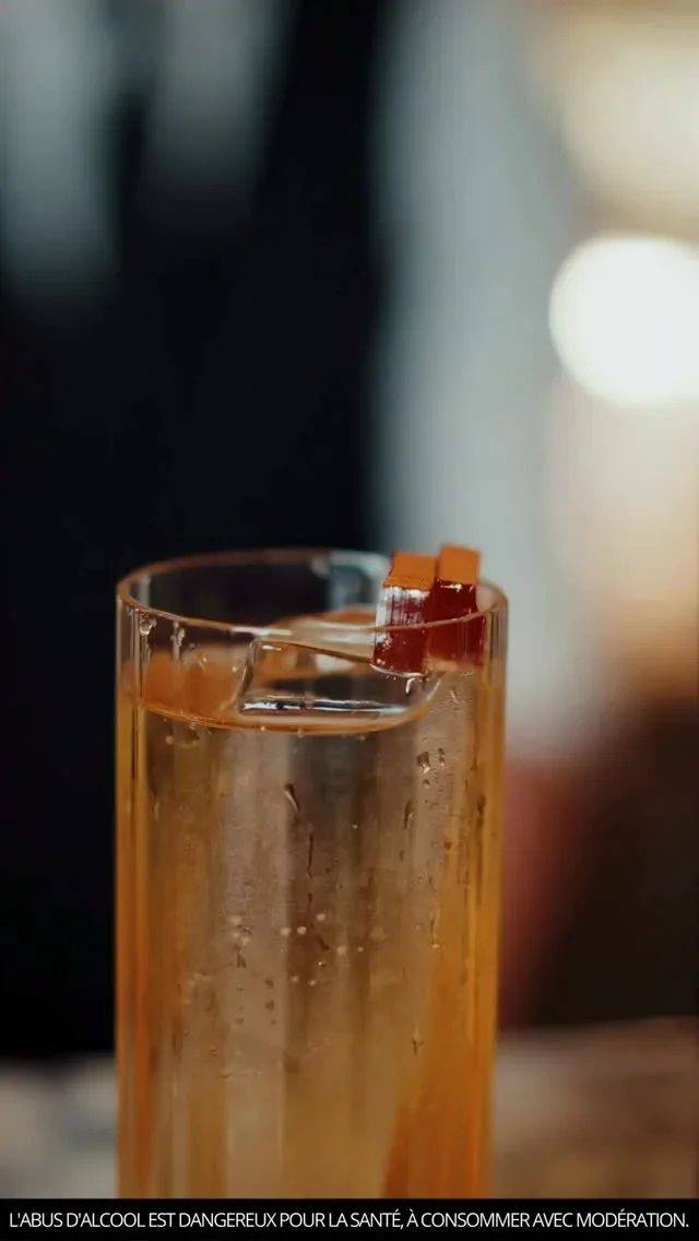 Cocktail ambré Noilly Prat avec zeste d'orange dans un verre highball, création mixologie Maison Noilly Prat Hérault