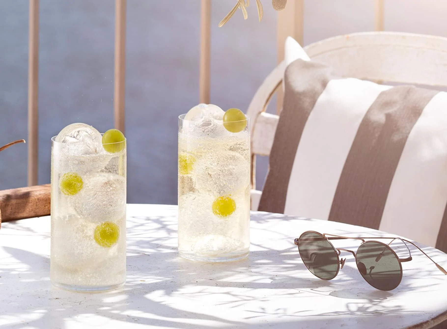 Cocktails Noilly Prat servis en terrasse avec raisins verts et glaçons, ambiance estivale Maison Noilly Prat Marseillan Hérault