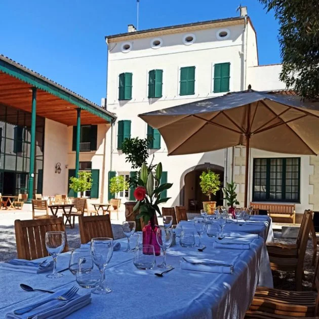 Vue extérieure de la Maison Noilly Prat avec terrasse dressée pour une réception à Marseillan, domaine mariage Hérault