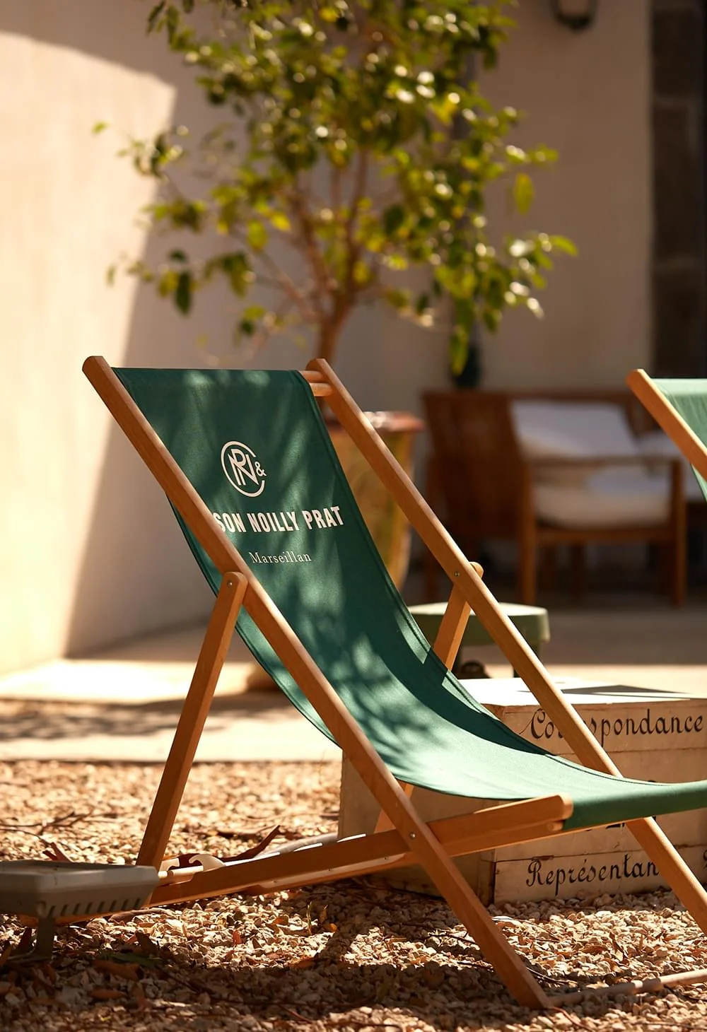 Transats verts Maison Noilly Prat dans la cour intérieure ensoleillée de Marseillan, espace détente Hérault