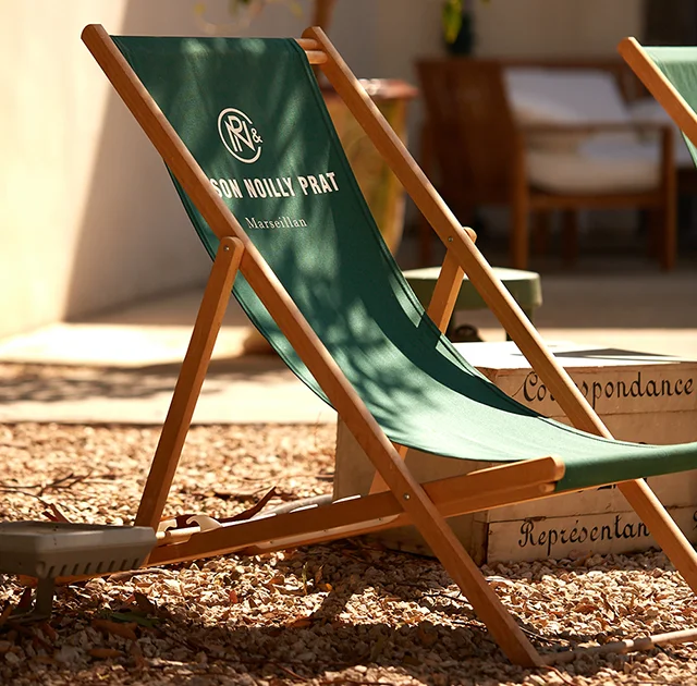 Transats verts Maison Noilly Prat dans le jardin ensoleillé du domaine à Marseillan, Hérault