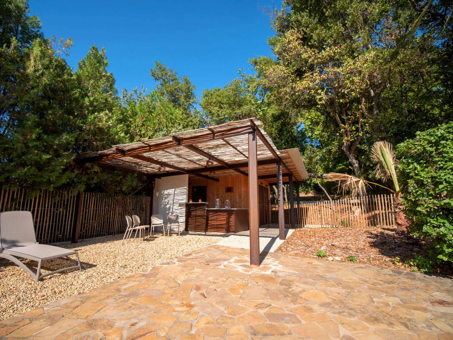 Bar de la piscine du Mas Aubrilha avec comptoir en acier corten et béton, logo arbre, décorations florales pour mariage Hérault